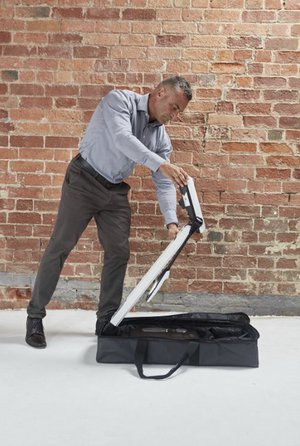 Man unpacking a white scooter from a black bag 